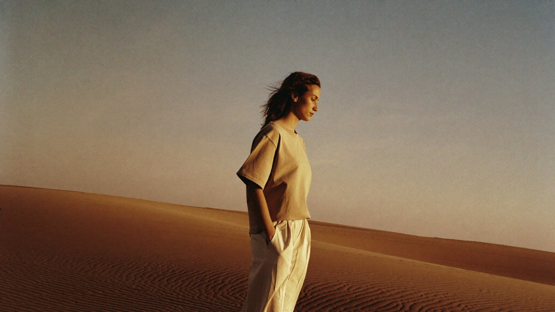 Golden-hour sunrise over the Egyptian desert — the HASK Boxy Tee, worn.